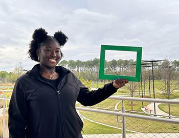 Girl Holidng Up a Green Square
