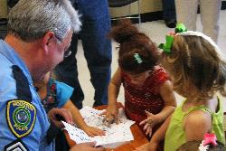 HPD Senior Police Officer Christopher Engelhardt fingerprints youngsters at today's kickoff event